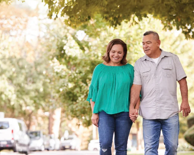 adult couple walking outside and both smiling while conversing