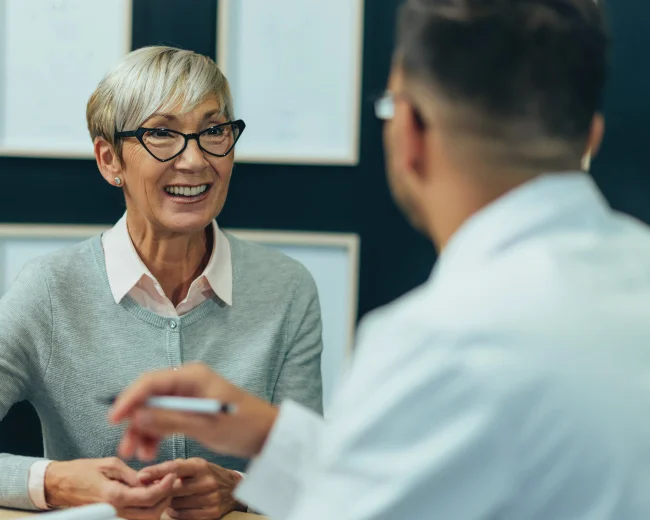 female patient smiling while in consolation with doctor