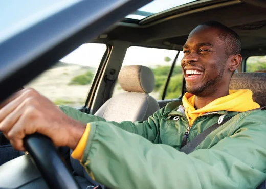 smiling young adult male driving with his windows down