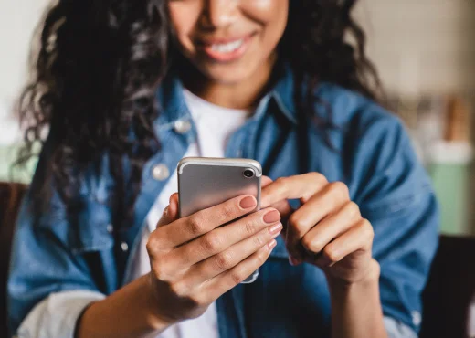 cropped photo of young adult female using smartphone for mobile banking