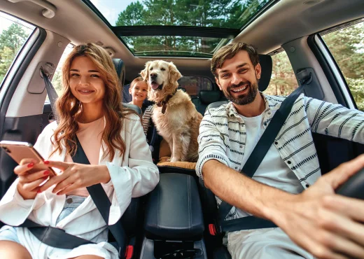 family with young daughter and Labrador in car for road trip