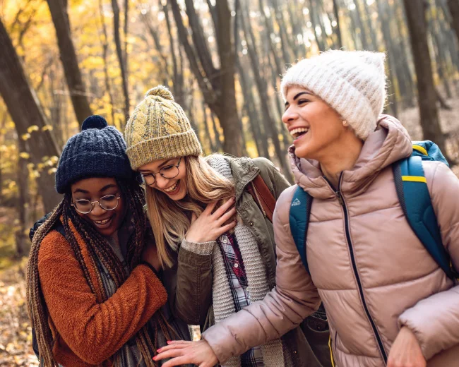 group of young adult women smiling together while on a fall hike